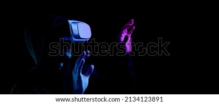 Vr glasses virtual reality. Young man in digital headset for virtual reality technology isolated on dark neon background. Amazing technology, online game, entertainment