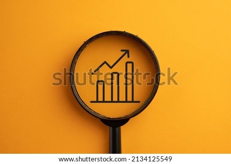 Growthing Bar concept.,View through a magnifying glass on growthing Chart icon over orange background. Royalty-Free Stock Photo #2134125549