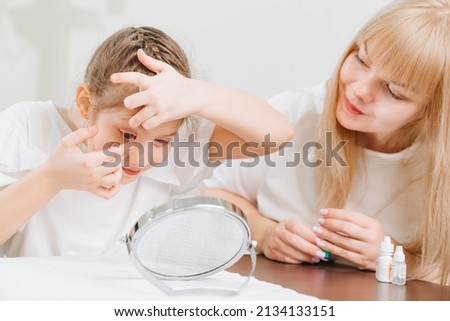 the ophthalmologist shows and explains to the girl how to use night treatment contact lenses. Advertising contact lenses for vision. Ophthalmology, optical store, health care and medicine. Royalty-Free Stock Photo #2134133151