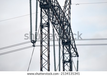 High voltage insulation string on steel pillar with electric power lines for safe delivering of electrical energy through cable wires on long distance