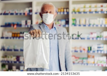 A happy old man holding bag with therapy at pharmacy. Royalty-Free Stock Photo #2134153635