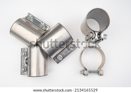 Several metal clamps. Galvanized hose clamps. Spare parts for auto repair close-up. Manufacture and sale of clamps made of steel. Metal spare parts for auto repair on light background Royalty-Free Stock Photo #2134165529