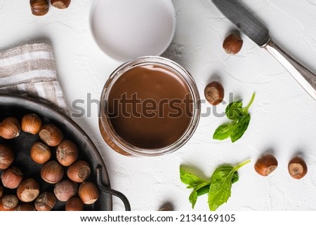 Chocolate spread or nougat cream with hazelnut set, on white stone table background, top view flat lay Royalty-Free Stock Photo #2134169105