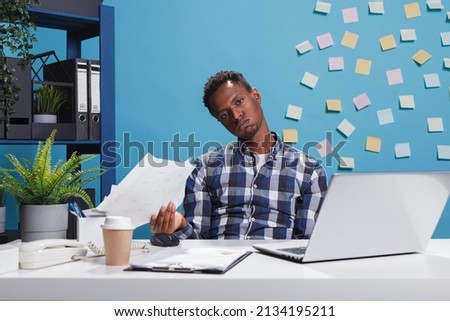 Exhausted bored business person sighing at desk while having company financial documentation. Fatigued office worker with burnout syndrome taking break from work because of tiredness.