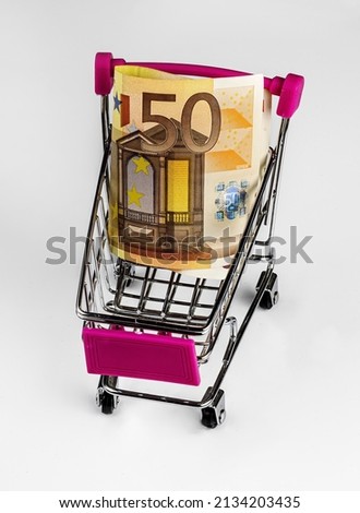 small market handcart with a euro banknote on a white isolated background close up, supermarket trolley with money  