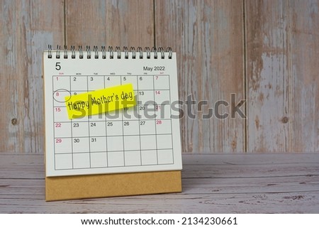 Happy Mother's Day written on stick note on white May 2022 calendar. Celebration concept.