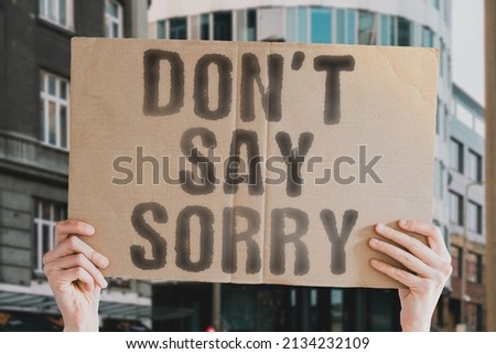 The phrase " Don’t say sorry " on a banner in men's hand with blurred background. Study. Shame. Wrong. Guilt. Final. Offer. Feel. Action. Choice. Sad. Good. Excuse. No. Career. Back. Despair. Upset Royalty-Free Stock Photo #2134232109
