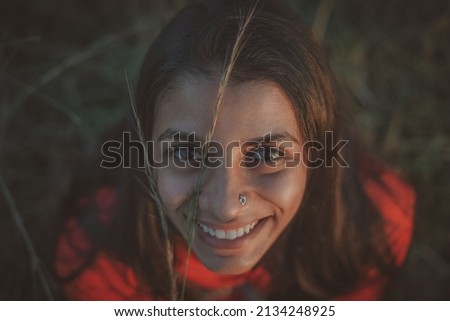 Portrait of Happy Indian Lady wearing red dress looking up. Selective focus with shalow depth of field.               