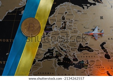Russian military aircraft on the map of Europe. And bitcoin on the Ukrainian flag. Concept.