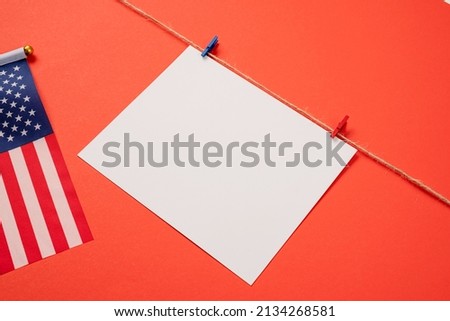 USA Memorial day, Presidents day, Veterans day, Labor day, or 4th of July celebration. Blank white paper for mockup design with red and blue clips on craft rope, red background