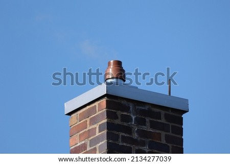 Red brick chimney against a blue sky
