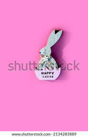 Easter wooden Bunny ornate,  isolated on pink background.Decorative Flat lay greeting advertising card spring Holiday concept. Copy space. Vertical image 