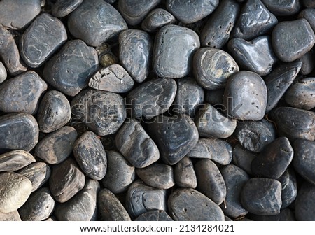 Several black stones laid on the ground, close-up photographs showing the texture of the details.