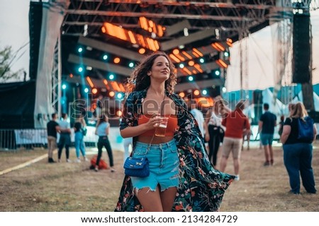 Beautiful woman drinking beer and having fun on a festival with her friends Royalty-Free Stock Photo #2134284729