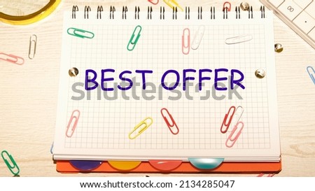 Best Offer text on a notebook in a cage with scattered paper clips on a notebook and a table.