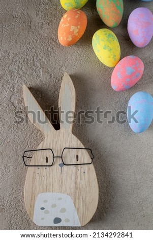 rabbit and colored easter eggs on a gray background