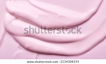 Thick pink creamy texture sliding down. Lather of lotion or cream creating ripples and waves. 