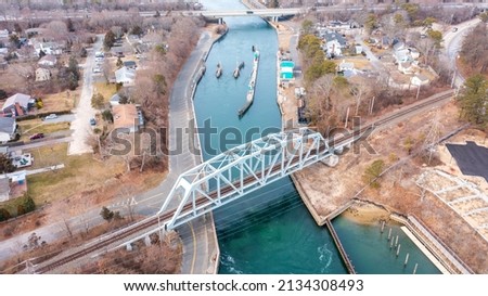 A high angle, aerial view over the Shinnecock Canal in Hampton Bays, Long Island, NY. Taken by a metal bridge for trains, shot on a sunny day with a drone.