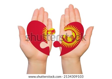 Woman hands are holding two parts of puzzle heart. National concept on white background. Kyrgyzstan