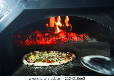 Italian pizza homemade in front of the oven.