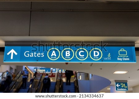 Airport sign board Gates A B C D Baggage Claim in interior air terminal