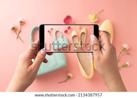 Woman taking photo of yellow ballet flats shoes and mint handbag with smartphone. Blogger, influencer or stylist capturing spring fashion accessories for social media. Pastel pink background.