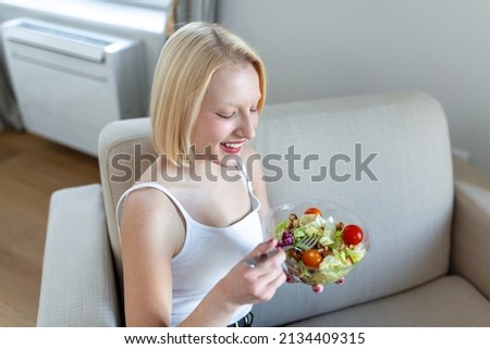 Young fit woman eating healthy salad after workout. Fitness and healthy lifestyle concept. healthy young woman eating green salad