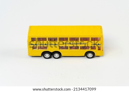 Miniature yellow tporist big bus isolated on white background, double decker metal bus mini toy front view, slanted angle object