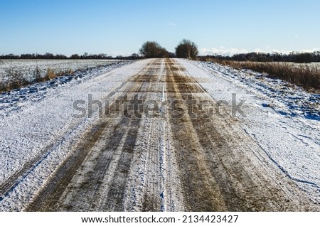 The road sprinkled with sand so that the cars do not slip goes into the distance Royalty-Free Stock Photo #2134423427