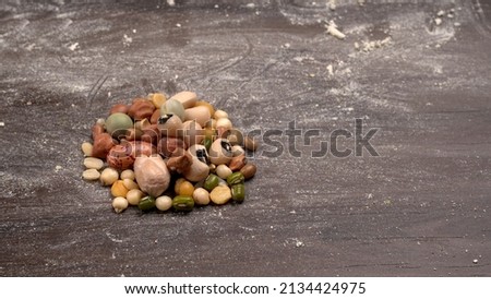 Mixed dry organic cereal and grain seed pile on wooden background. For healthy food ingredient or carbohydrate food type and agricultural product concept. Royalty-Free Stock Photo #2134424975