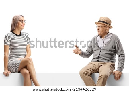 Elderly man talking to a young blond woman seated on a panel isolated on white background