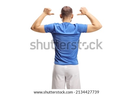 Rear view shot of a soccer player in a blue top and white shorts showing his back isolated on white background Royalty-Free Stock Photo #2134427739