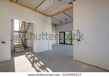 empty white room without repair and furniture with scaffolding with wooden stairs Royalty-Free Stock Photo #2134444357