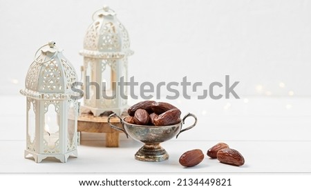 Ramadan Kareem and iftar muslim food, holiday concept. Bowl with dried dates and latterns with candles. Celebration idea