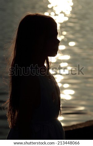 Beautiful silhouette of a little girl at sunset