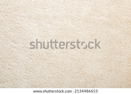 Beige new fluffy home carpet background. Closeup. Empty place for text.