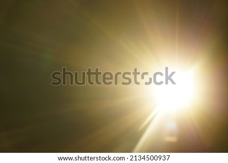 blurred image. shiny sun, sunbeams, sunrays, sunshine design. Yellow warm light effect, sun rays, golden beams isolated on black background. star dust Royalty-Free Stock Photo #2134500937