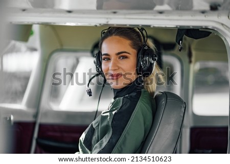 Beautiful adult woman, comfortably sitting in the cockpit, looking at the camera. Royalty-Free Stock Photo #2134510623