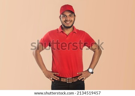 Confident Delivery Man Wear Red Outfit Smiling Hands Arms Waist Isolated Color Color Background Royalty-Free Stock Photo #2134519457