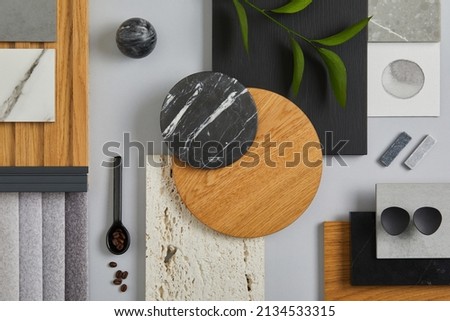 Elegant architect moodboard flat lay composition in light grey, black and brown color palette with textile and paint samples, wooden panels and marble tile. Top view. Copy space. Template.
