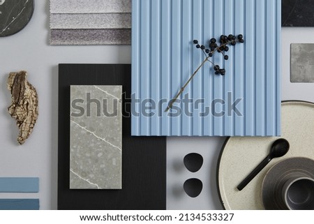 Flat lay composition of stylish architect moodboard with samples of textile, paint, blue wooden lamella panels and tiles. White, black, blue and light grey color palette. Copy space. Template.