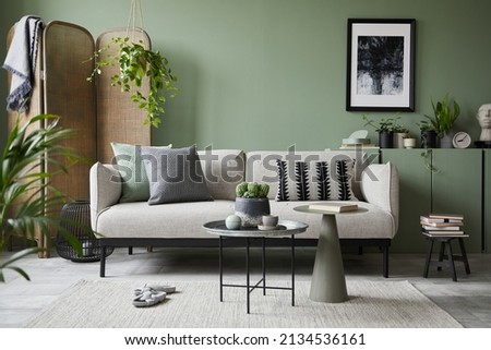 Stylish composition of modern living room interior. Mock up poster frame, modern sofa, folding screen, plants and personal accessories. Eucalyptus wall. Home staging. Template. Copy space.  Royalty-Free Stock Photo #2134536161