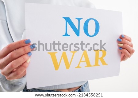 Close-up of a young woman holding a no war poster