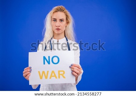A female doctor holds a no war poster on a blue background