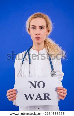 A female doctor holds a no war poster on a blue background