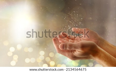 Praying religious hands concept with glitters and lights background.  Side view.