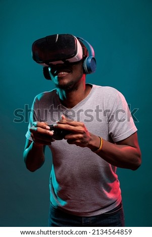 Focused man using controller and vr glasses to play futuristic game online. Gamer playing virtual reality simulation on interactive headset with joystick, advertising 3d modern technology. Royalty-Free Stock Photo #2134564859