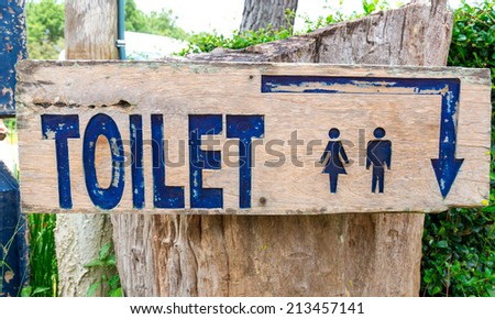 A wooden sign of entrance to a toilet
