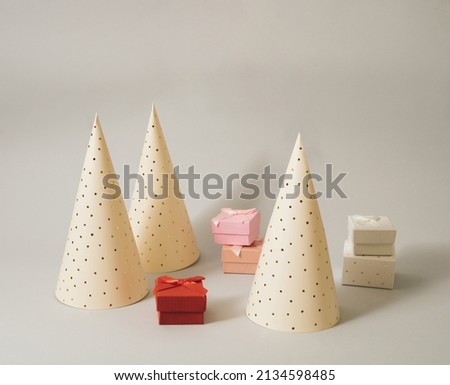 Celebration arrangement with party hats associating Christmas trees and presents around them. Minimal background.
