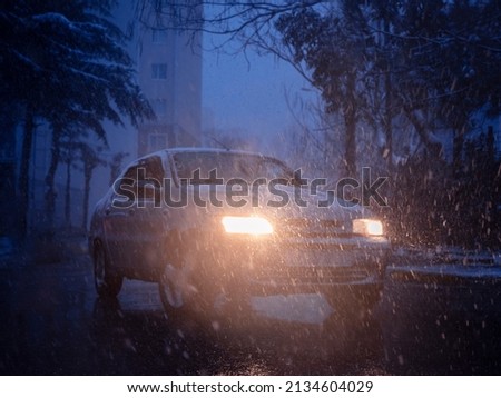 car light in blizzard, front view